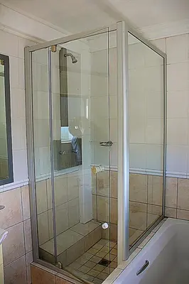 a glass shower in a bathroom with a tub at OCEAN VIEW, Blouberg Beach, Sunsets & Kite Beach in Bloubergstrand