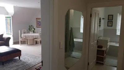 a living room with a mirror and a room with a table at Mountain View Self-Catering Apartments in Somerset West