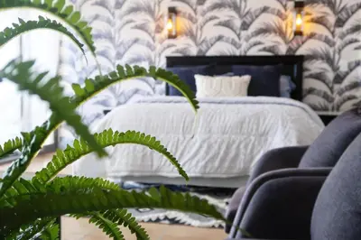 a bedroom with a white bed and a green plant at Beachfront Gem / Free Parking / A/C in Cape Town