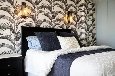 a bedroom with a bed with a wall mural at Beachfront Gem / Free Parking / A/C in Cape Town