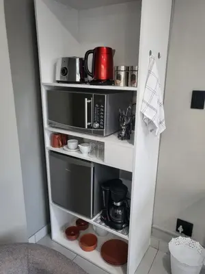 a kitchen shelf with a microwave and a coffee maker at Willow Retreat Blouberg in Cape Town