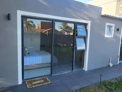a room with sliding glass doors with a bed outside at Willow Retreat Blouberg in Cape Town