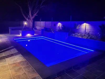 a swimming pool in a backyard at night at Willow Retreat Blouberg in Cape Town