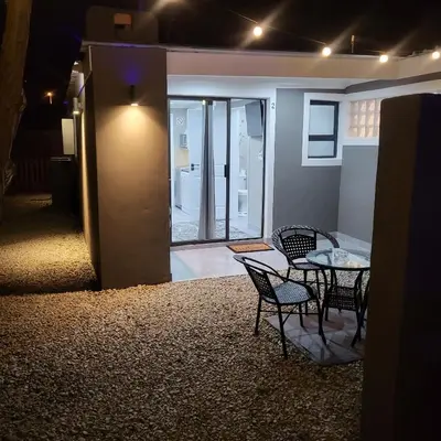 a dining room with a table and chairs in a room at Willow Retreat Blouberg in Cape Town