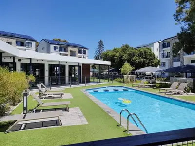 a swimming pool with lounge chairs next to a building at Casa The Jade in Cape Town