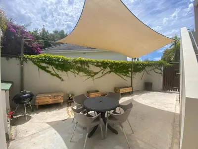 a patio with a table and chairs under awning at Bing Heights Suite in Hermanus