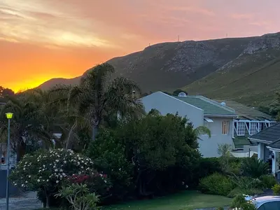 a house with palm trees and a mountain in the background at Bing Heights Suite in Hermanus