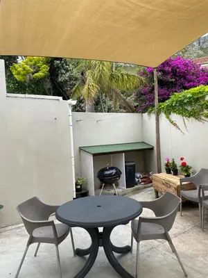 a table and chairs under an umbrella on a patio at Bing Heights Suite in Hermanus