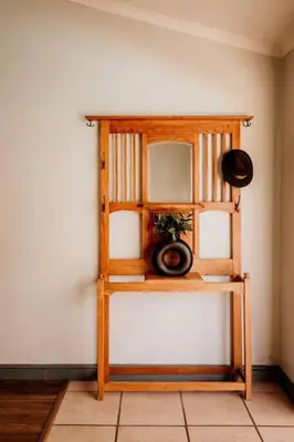a wooden shelf with a mirror on a wall at Villa Visser in Cape Town