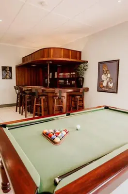 a billiard table in a living room with a bar at Villa Visser in Cape Town