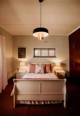 a bedroom with a large white bed with two lamps at Villa Visser in Cape Town
