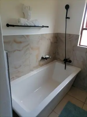 a white bath tub sitting in a bathroom at Capetown Adilo Villa in Cape Town
