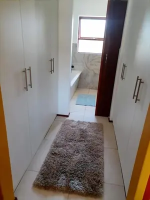 a bathroom with white doors and a rug on the floor at Capetown Adilo Villa in Cape Town