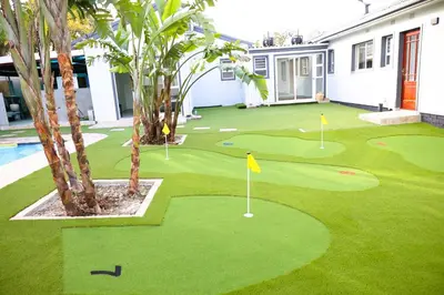 a golf course with a putting green and palm trees at El-Gibor Best Guest House in Cape Town