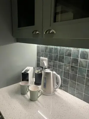 a kitchen counter with two cups and a coffee maker at Two on Milner - ARUM COTTAGE - Stylish open-plan Guesthouse in Rondebosch in Cape Town