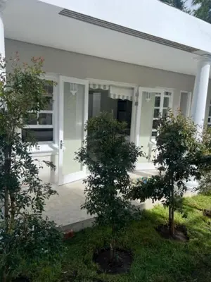 a white house with two trees in front of it at Two on Milner - ARUM COTTAGE - Stylish open-plan Guesthouse in Rondebosch in Cape Town