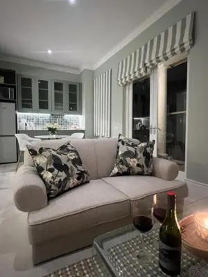 a living room with a couch and a table at Two on Milner - ARUM COTTAGE - Stylish open-plan Guesthouse in Rondebosch in Cape Town