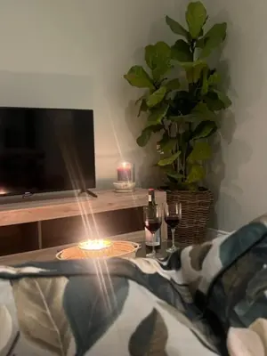 a table with a candle and two glasses of wine at Two on Milner - ARUM COTTAGE - Stylish open-plan Guesthouse in Rondebosch in Cape Town