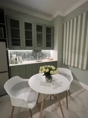 a kitchen with a table with a vase of flowers on it at Two on Milner - ARUM COTTAGE - Stylish open-plan Guesthouse in Rondebosch in Cape Town