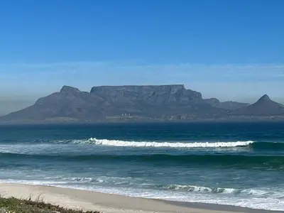 a view of a beach with a mountain in the background at Cowrie Cottage Self Catering in Cape Town