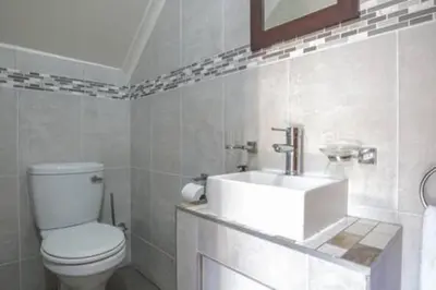 a white bathroom with a toilet and a sink at Howard Davis 28B by CTHA in Cape Town