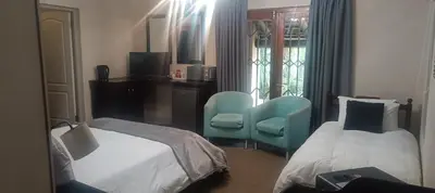 a hotel room with two beds and a chair at Traduire in Cape Town