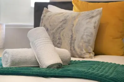 a stack of towels sitting on a bed at Sea Spray B404 in Cape Town
