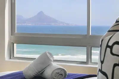 a towel sitting on a bed in front of a window at Sea Spray B404 in Cape Town