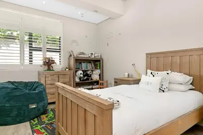 a bedroom with a large bed and a window at On the Greens Villa in Cape Town