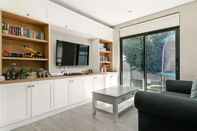 a living room with a tv and a couch and a table at On the Greens Villa in Cape Town