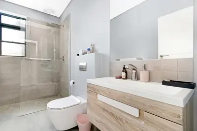 a bathroom with a sink and a toilet and a shower at On the Greens Villa in Cape Town