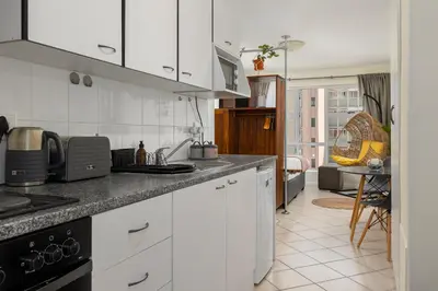 a kitchen with white cabinets and a counter top at Ocean View B201B in Cape Town