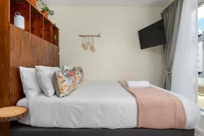 a bedroom with a bed and a tv on a wall at Ocean View B201B in Cape Town