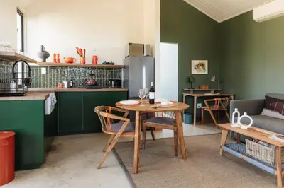 a kitchen with green walls and a table with chairs at untether on Olive View in Wellington