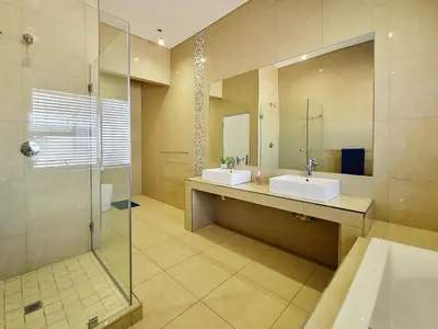 a bathroom with two sinks and a shower at Kite, Wind, Waves Beach Villa in Cape Town