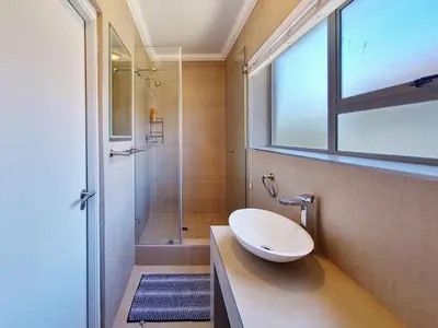 a bathroom with a sink and a shower at Kite, Wind, Waves Beach Villa in Cape Town