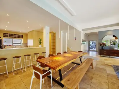 a large kitchen with a wooden table and chairs at Kite, Wind, Waves Beach Villa in Cape Town