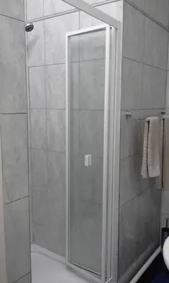 a shower with a glass door in a bathroom at 68 On Hofmeyr in Strand