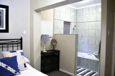a bedroom with a bed and a bathroom with a tub at 68 On Hofmeyr in Strand