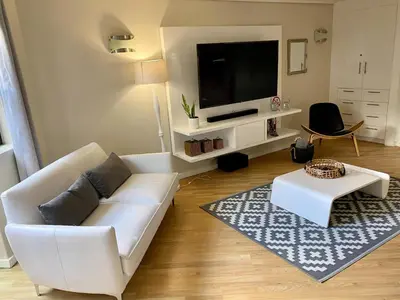 a living room with a white couch and a flat screen tv at Rose’s Place in Durbanville