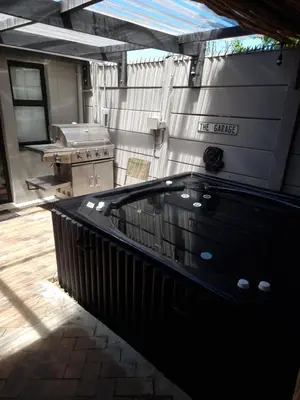 a patio with a hot tub and a grill at Rose’s Place in Durbanville