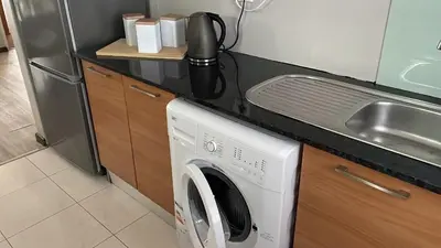 a kitchen with a washing machine and a sink at 104 Horizon Bay Bloubergstrand in Bloubergstrand