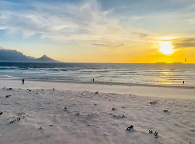 a beach with people on the sand and the ocean at 104 Horizon Bay Bloubergstrand in Bloubergstrand