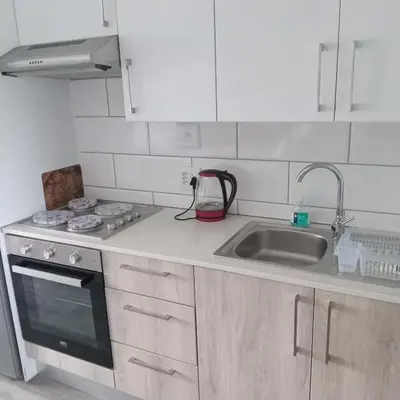 a white kitchen with a sink and a stove at Cederberg Estate in Cape Town