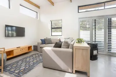 a living room with a couch and a tv at Mountain and Sea Cottage in Hermanus