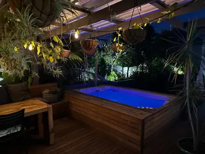 a hot tub in a backyard with plants at Green Oasis in Blouberg Hot Tub Kids Paradise in Cape Town