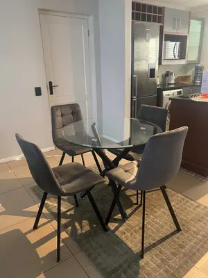 a glass dining table and chairs in a kitchen at The CoziPlace Italia in Cape Town
