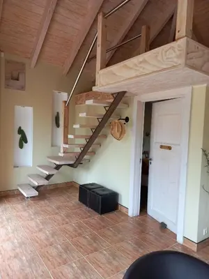 a living room with a staircase in a house at Basco River Lodge Luxury Apartment in Grabouw