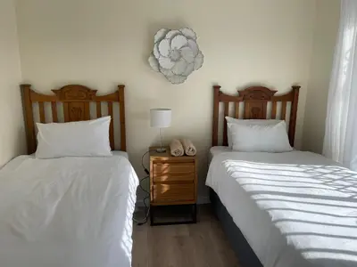 two beds sitting next to each other in a bedroom at Silver Sunsets Self-Catering Apartments in Cape Town