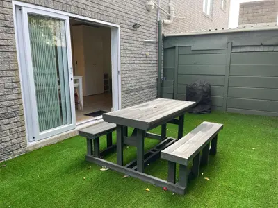 a picnic table and two benches on a lawn at Silver Sunsets Self-Catering Apartments in Cape Town